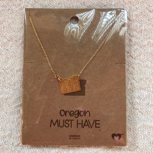 New in package, gold tone, “Oregon” state shaped necklace with 16” chain.